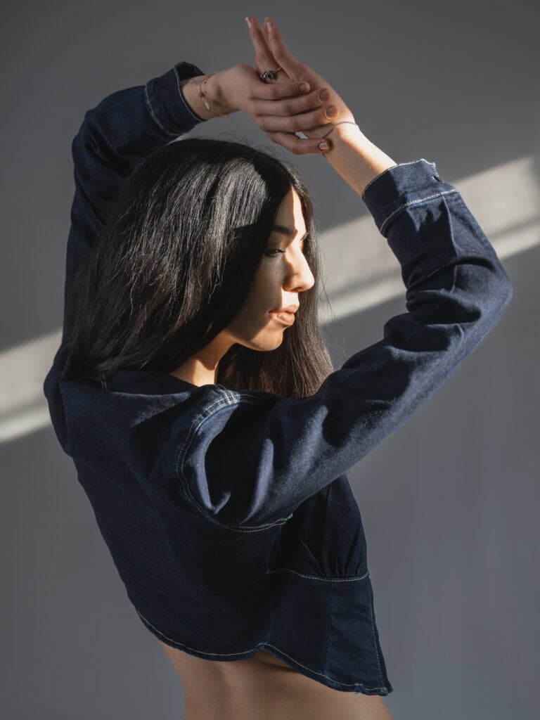 Photo artistique de femme en denim avec lumière naturelle.