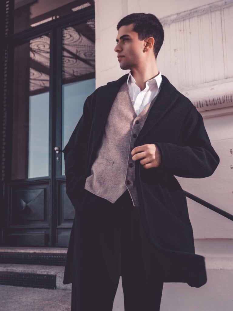 Homme habillé en costume devant bâtiment moderne, style professionnel et sophistiqué.