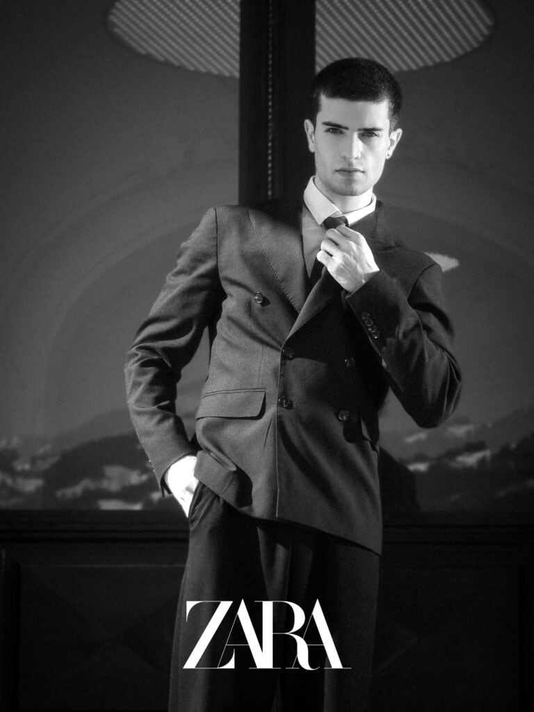 Baladeur homme en costume noir sophistiqué, portrait en noir et blanc.