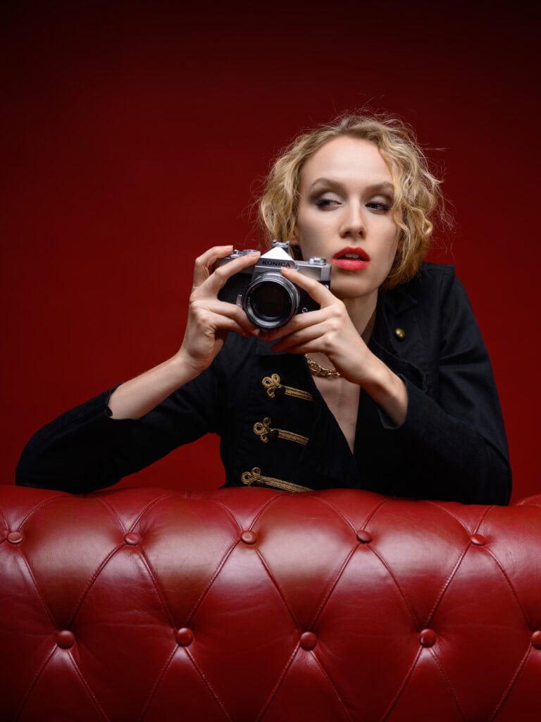 Femme avec appareil photo, portrait en studio, ambiance artistique et créative.