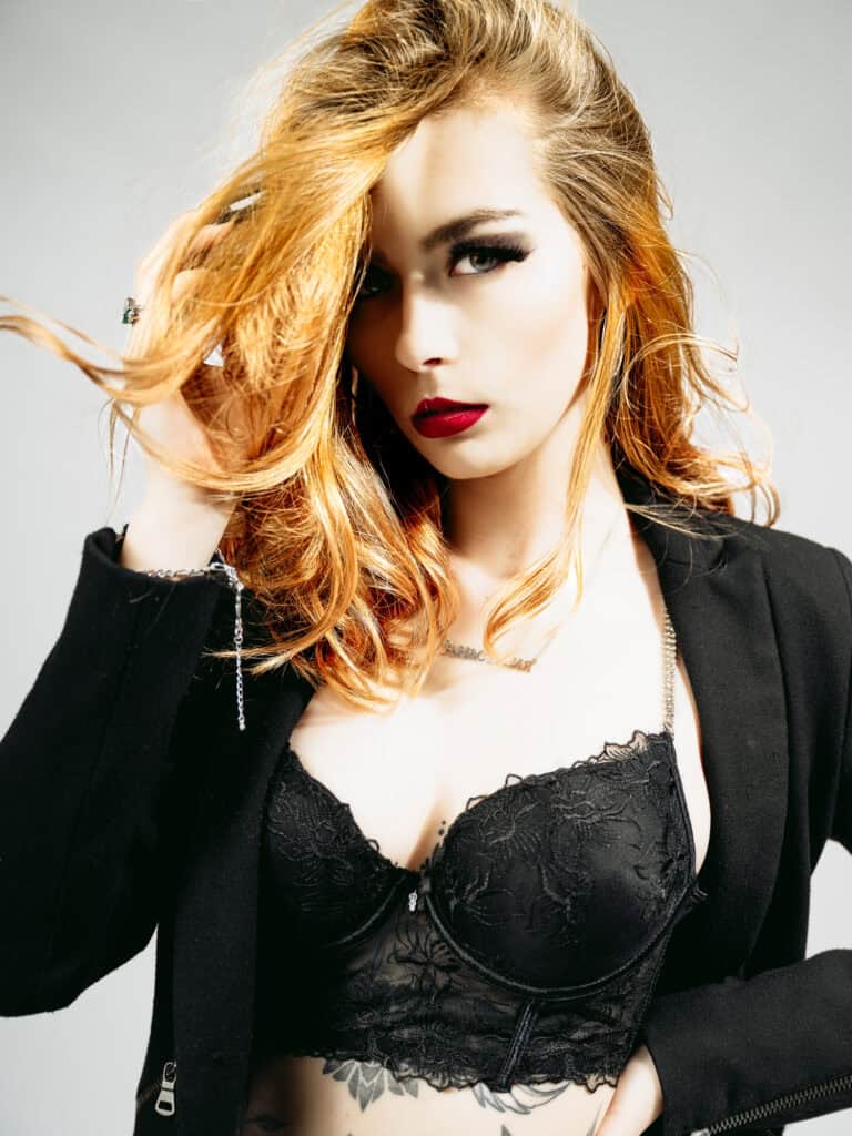 Balade de portrait en studio avec modèle aux cheveux roux et maquillage sophistiqué.