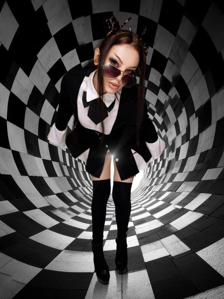 Femme mode dans un tunnel optique avec lunettes de soleil et tenue élégante.