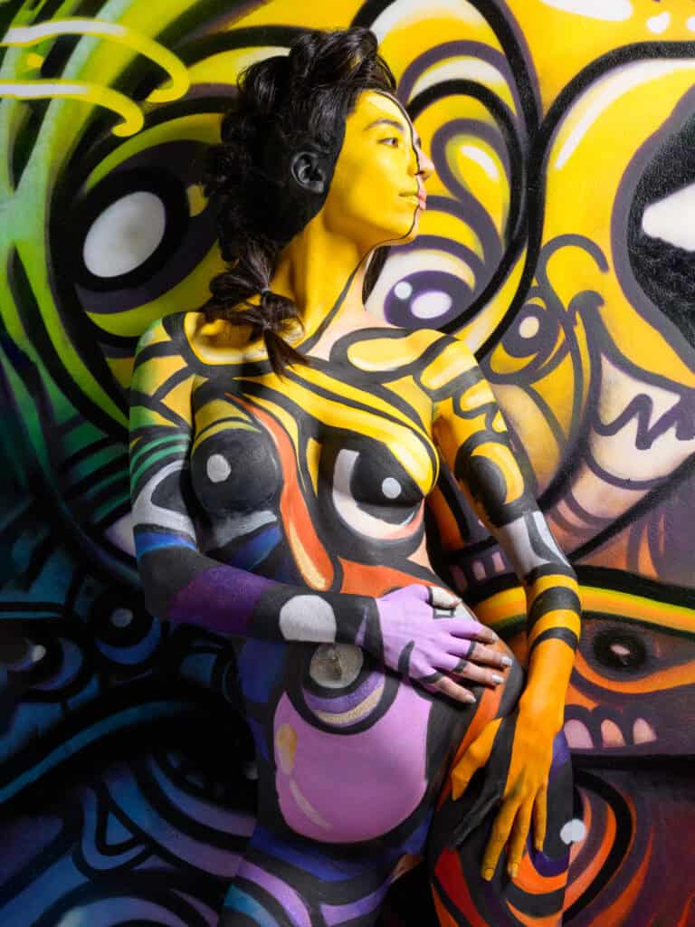 Modèle peint en corps avec art urbain coloré pour séance photo artistique.