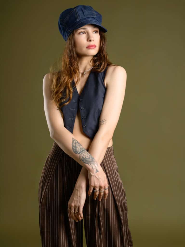 Femme en tenue décontractée avec chapeau, regardant à gauche.