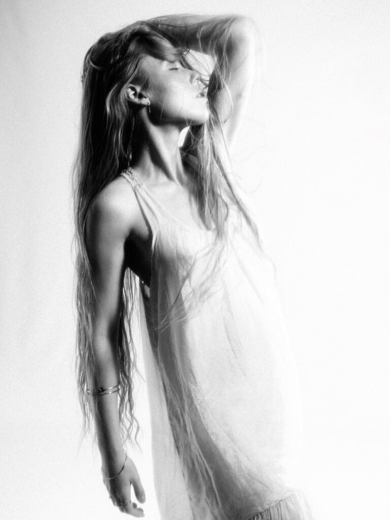 Portrait artistique d'une femme en noir et blanc avec pose élégante.