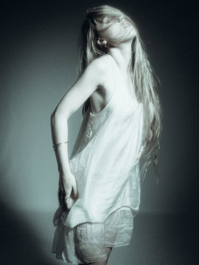 Portrait artistique d'une femme en robe légère, style minimaliste et élégant.