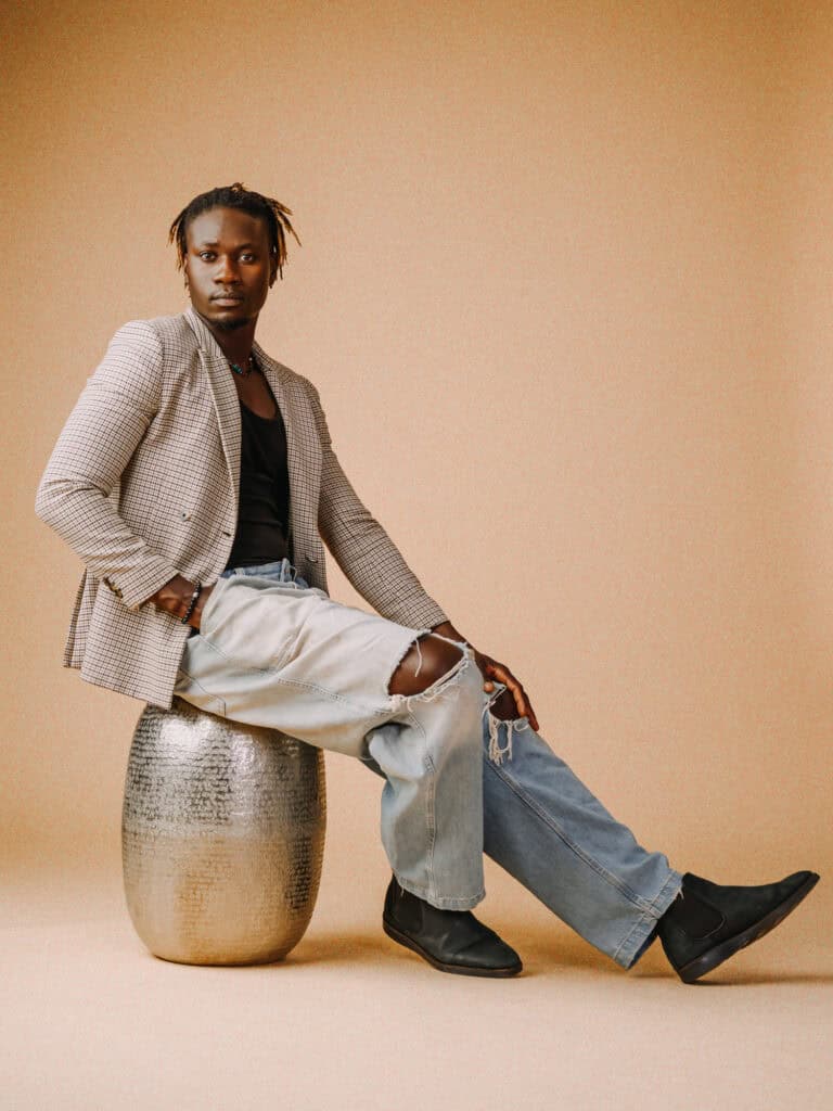 Personne assise sur un tabouret en studio, style décontracté et mode urbaine.