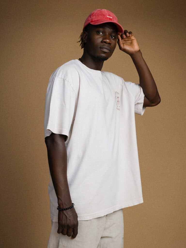 Balade urbaine avec style : homme décontracté portant une casquette rouge et un t-shirt blanc.