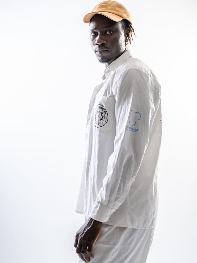 Vêtement de mode homme blanc avec casquette beige, portrait en studio, style décontracté.