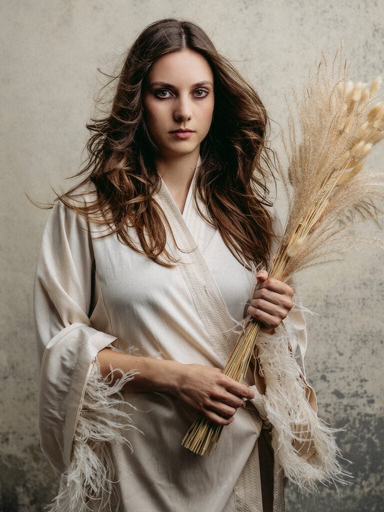 Femme avec bouquet de pampa, portrait élégant en studio.