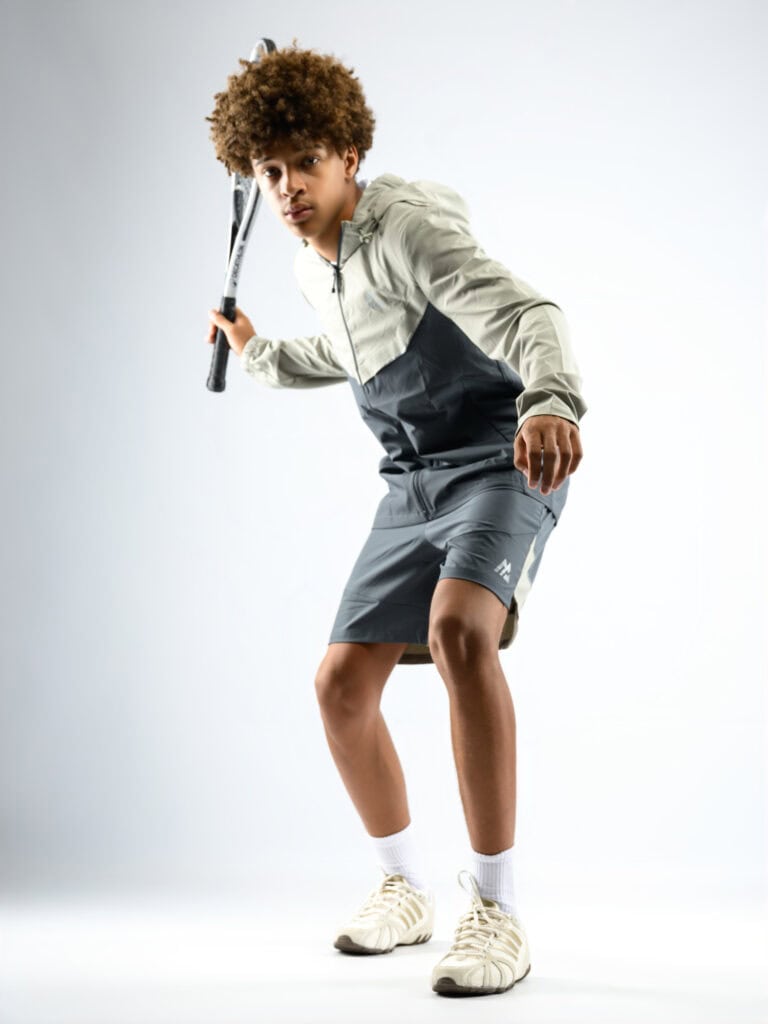 Jeune athlète prêt à jouer au tennis ou badminton avec raquette.