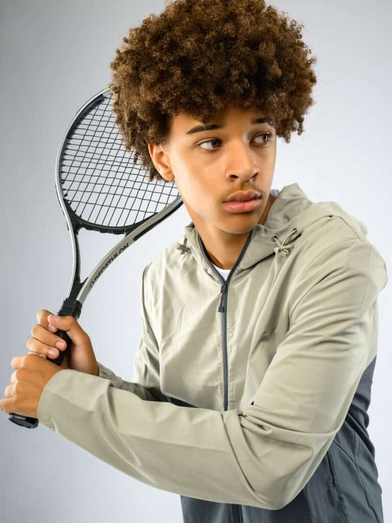 Jeune Homme avec raquette de tennis, portrait en studio.