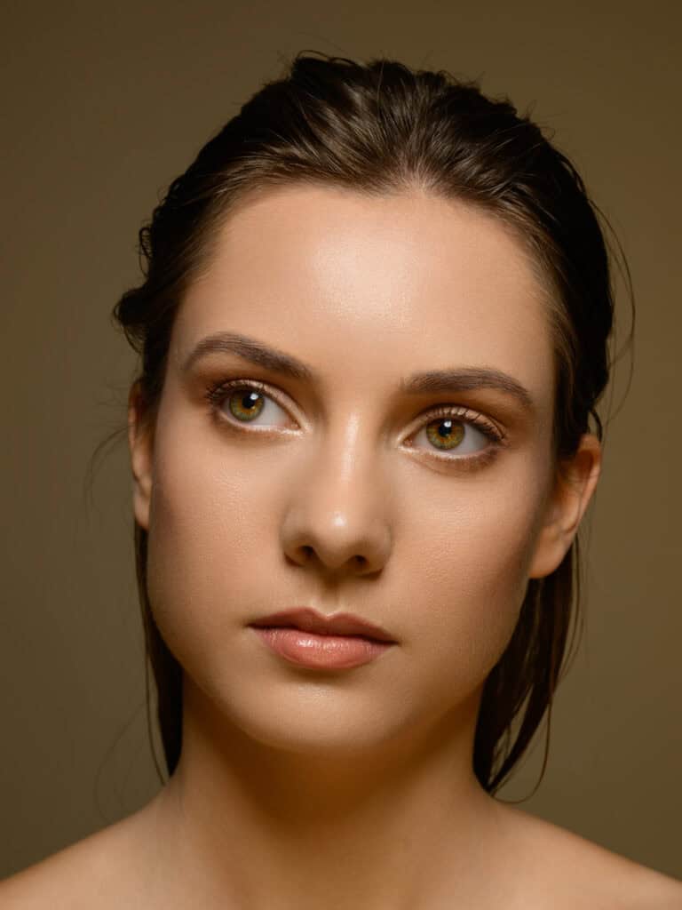 Portrait d'une femme avec maquillage naturel et cheveux bruns.