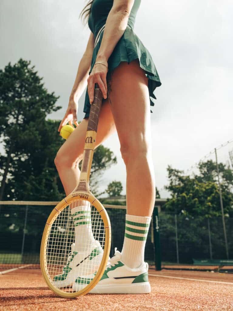 Joueuse de tennis avec raquette sur court en extérieur.