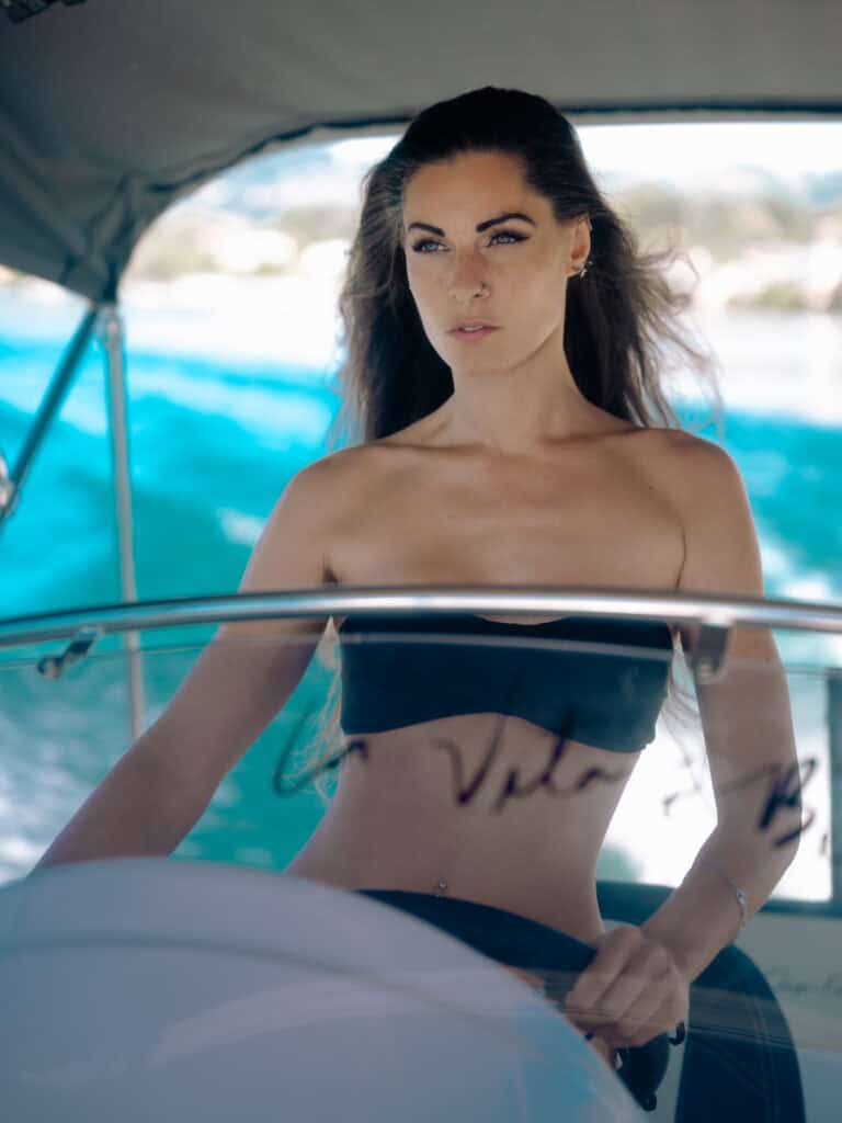 Femme élégante sur un bateau en mer, portrait professionnel en extérieur.