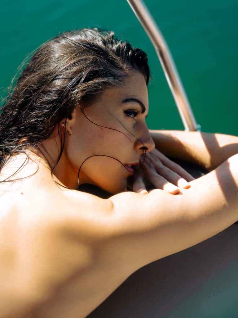 Femme relaxant sur un bateau en mer, paysage marin paisible.