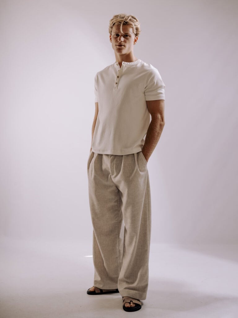 Jeune homme mode avec veste beige et jeans, portrait studio.